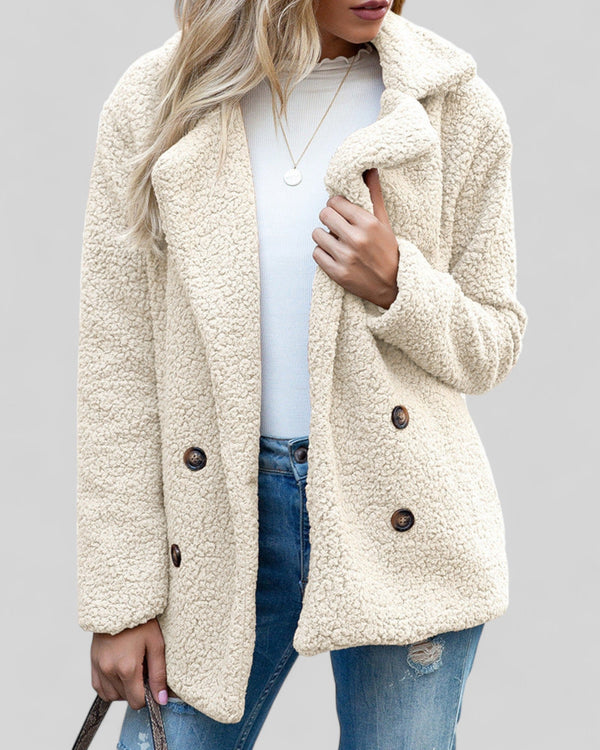 Vrouw in beige teddyjas, witte top en blauwe jeans. Modieuze winterjas, knopen, casual stijl. Perfect voor herfst- en wintermode.