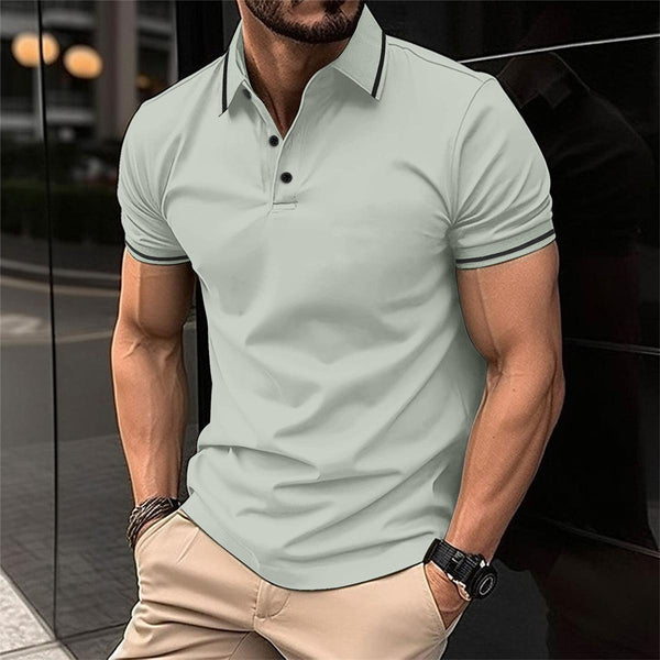 Man in lichtgroen poloshirt en beige broek, staand buiten. Modieuze herenkleding, casual stijl, zomermode.