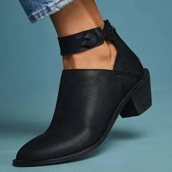 Zwarte leren enkellaars met gevlochten enkelband, lage hak en spitse neus, perfect voor damesmode en casual outfits.