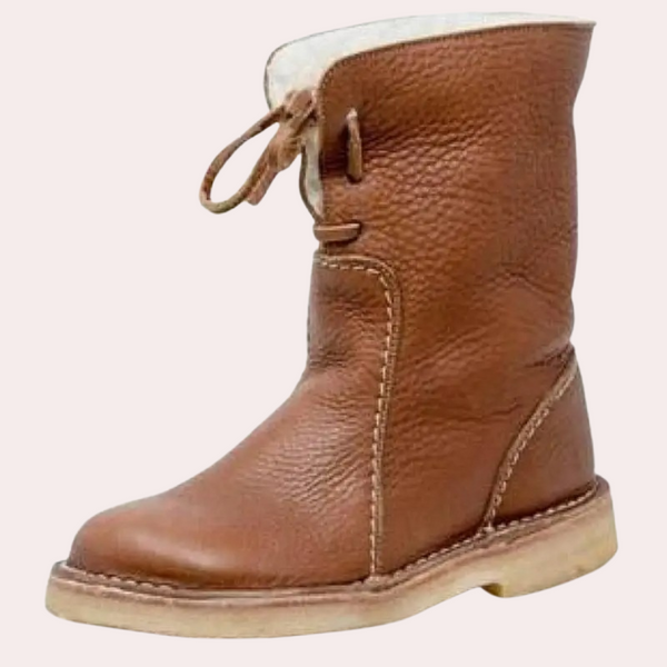 Bruine leren laars met veters, schapenvacht voering en crèmekleurige zool. Stijlvolle winterlaars voor heren, duurzaam en comfortabel.