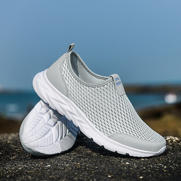 Grijze ademende sportschoenen met witte zool, ideaal voor hardlopen en wandelen. Lichtgewicht en comfortabel ontwerp voor dagelijks gebruik.