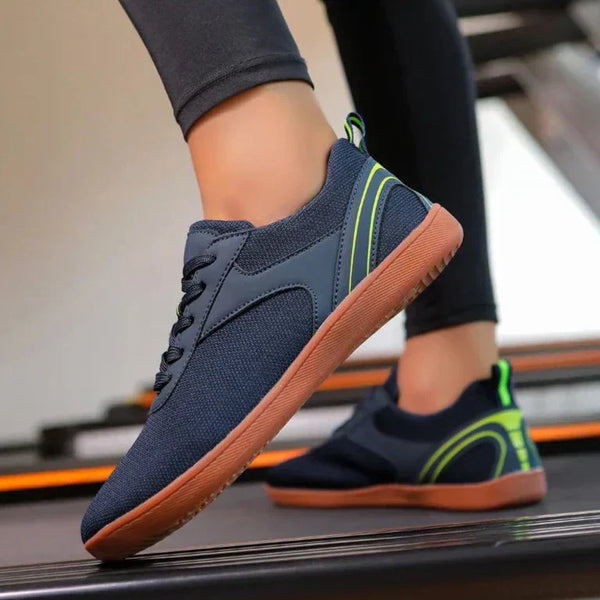Blauwe sportschoenen met groene accenten en bruine zolen op een loopband. Comfortabele hardloopschoenen voor dames, ideaal voor fitness en training.