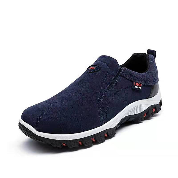 Donkerblauwe herenschoen, slip-on wandelschoen met zwarte zool en rode accenten, ideaal voor outdooractiviteiten. Comfortabele UKF sportstijl.