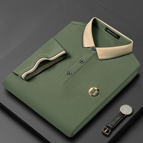 Groene polo met beige kraag, opgevouwen op een donkere achtergrond, naast een groene leren horloge. Stijlvolle herenkleding, casual mode.