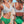 Vrouw in gestreepte bikini-top en groene high-waist bikini op strand. Zomermode, strandkleding, damesbadmode, trendy badpak, strandvakantie.