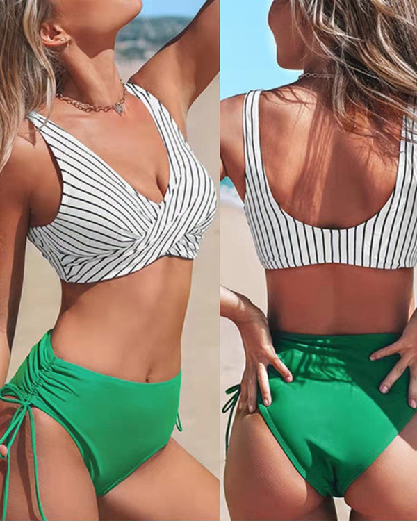 Vrouw in gestreepte bikini-top en groene high-waist bikini op strand. Zomermode, strandkleding, damesbadmode, trendy badpak, strandvakantie.