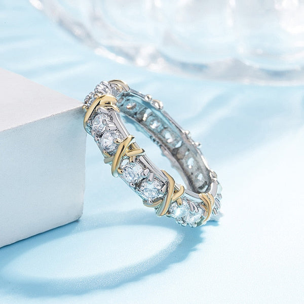 Gouden en zilveren ring met diamanten op blauwe achtergrond, luxe sieraden, elegante damesring, glinsterende edelstenen, stijlvolle accessoire.