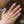 Twee zilveren ringen met gedetailleerd gravureontwerp op vingers van een persoon, close-up. Stijlvolle sieraden, handaccessoires, zilveren ringen.