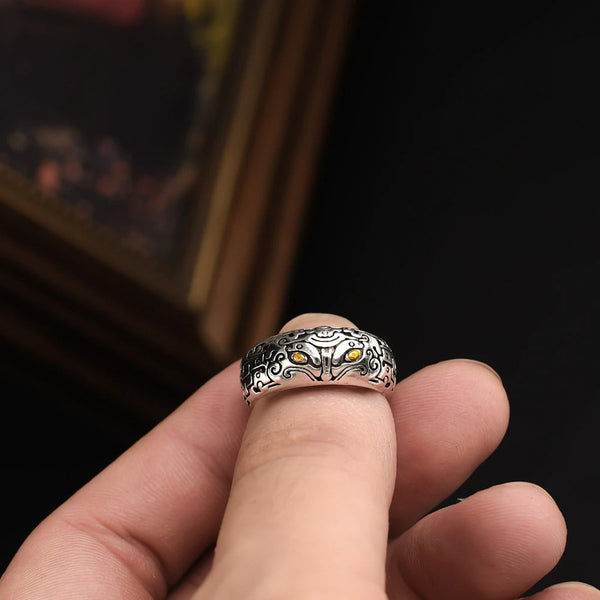 Zilveren Vikingring met gedetailleerd wolfontwerp, vastgehouden tussen vingers. Perfecte accessoire voor liefhebbers van Noorse mythologie en sieraden.