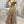 Vrouw in elegante, asymmetrische avondjurk met bloemenprint en hoge split, perfect voor galafeest of bruiloft. Trendy mode, opvallende stijl.