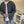 Man in grijze gebreide trui met witte T-shirt en blauwe jeans in moderne keuken. Casual herenkleding, stijlvolle outfit, comfortabele mode.