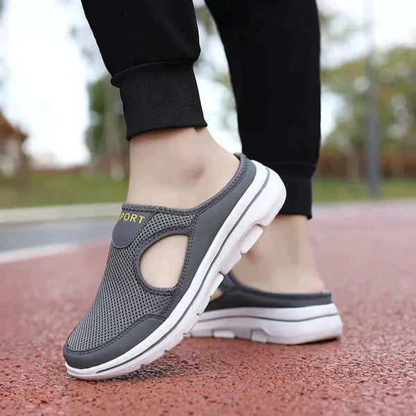 Grijze sportieve instapschoenen met ademend mesh bovenwerk en witte zool, ideaal voor wandelen en casual gebruik. Comfortabele en modieuze sneakers.