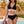 Vrouw in zwarte bikini met kleurrijke band, bij zwembad. Zomerse strandmode, trendy badkleding, vakantie outfit. Tropische achtergrond met palmbomen.