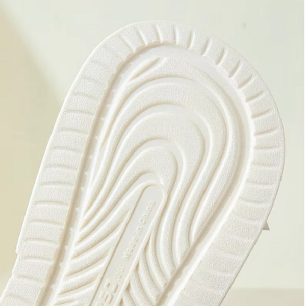 Witte rubberen schoenzool met golvend profielpatroon, antislip ontwerp, close-up. Ideaal voor sneakers, biedt grip en duurzaamheid.