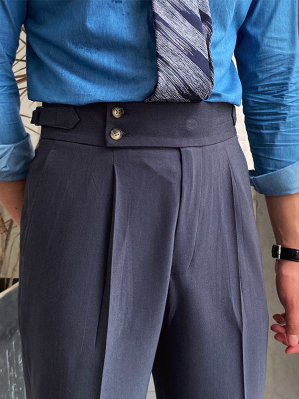 Blauwe overhemd en grijze pantalon met hoge taille en dubbele knopen, gedragen door een man. Stijlvolle zakelijke outfit met stropdas.