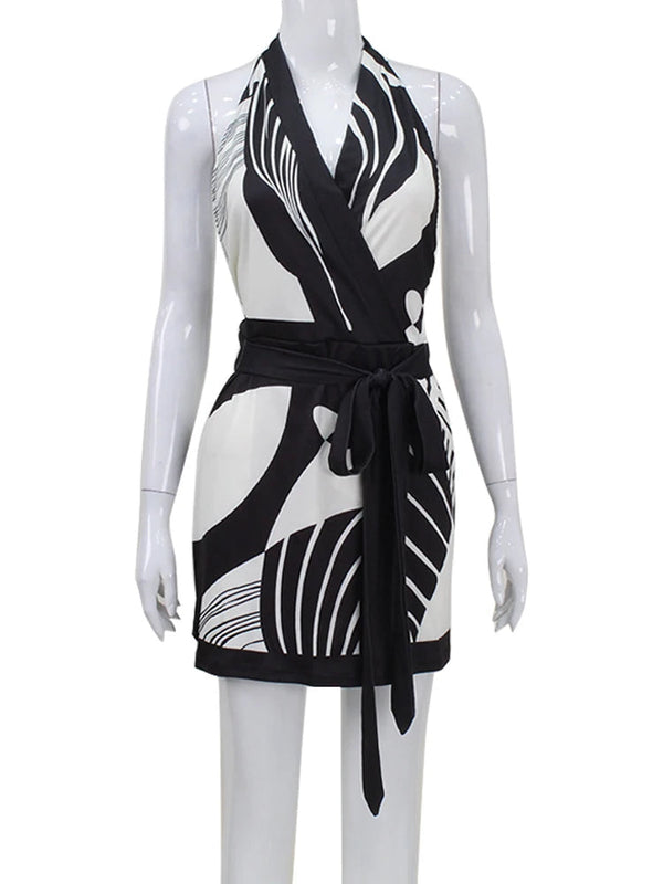 Zwart-witte halterjurk met abstracte print en strikceintuur, perfect voor zomermode. Elegante dameskleding, trendy en stijlvol ontwerp.
