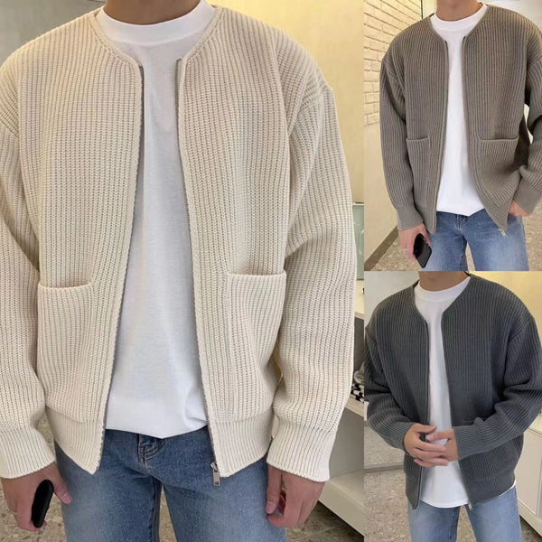 Drie mannen dragen gebreide vesten in crème, grijs en donkergrijs, gecombineerd met witte T-shirts en blauwe jeans. Stijlvolle herenkleding.