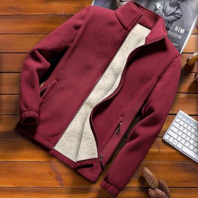 Bordeauxrode fleecejas met ritssluiting en zachte voering, casual herenkleding, warme winterjas, stijlvolle outdoor outfit, houten achtergrond.