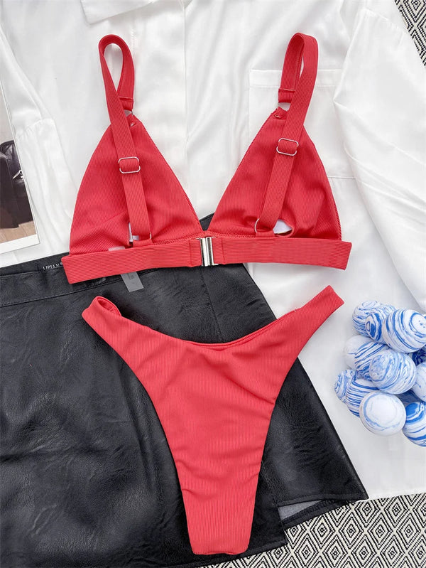 Rode bikini set met triangel top en hoge taille slip, liggend op zwart-witte achtergrond. Perfect voor strandmode en zomerse stijl.