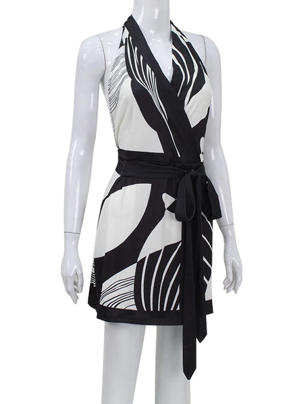 Zwart-witte halterjurk met abstract patroon, tailleband en knielengte. Perfect voor zomermode en casual chique outfits.