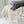 Beige en grijze gebreide dekens met kwastjes op metalen draadmand, stijlvolle woondecoratie, zachte textuur, Scandinavisch interieurontwerp.