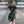 Vrouw in zwarte cheongsam-jurk met drakenprint, poseert in parkeergarage. Modieuze outfit, trendy stijl, moderne modefotografie.