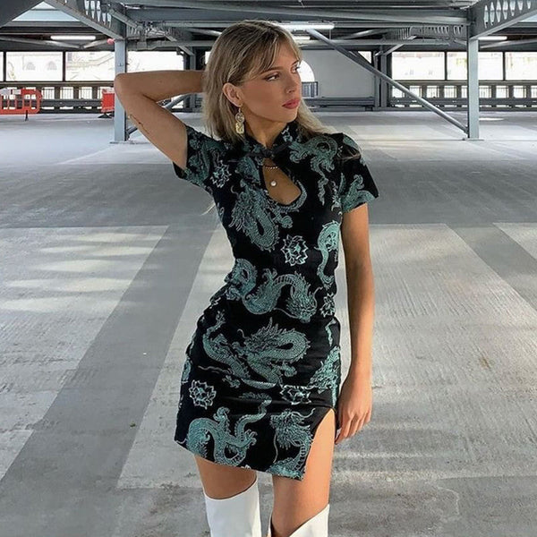 Vrouw in zwarte cheongsam-jurk met drakenprint, poseert in parkeergarage. Modieuze outfit, trendy stijl, moderne modefotografie.