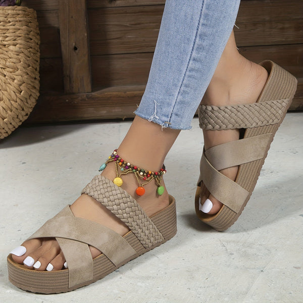 Beige dames sandalen met gevlochten bandjes en sleehak, gedragen met kleurrijke enkelband, op een lichte vloer. Perfect voor zomerse casual outfits.