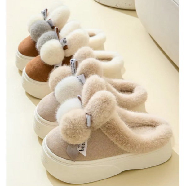 Pluche pantoffels met dikke zolen en pompons, beige en bruin, comfortabel en warm, perfect voor binnengebruik. Ideaal voor koude winterdagen.