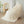 Crèmekleurige geribbelde deken op moderne fauteuil, minimalistisch interieur, houten vloer, decoratieve vaas, stijlvolle woonaccessoires.