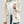 Vrouw in beige teddyjas, witte top en blauwe jeans. Modieuze winterjas, knopen, casual stijl. Perfect voor herfst- en wintermode.