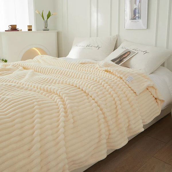 Crèmekleurige geribbelde deken op een bed met witte kussens in een moderne slaapkamer; stijlvolle en comfortabele slaapkamerinrichting.