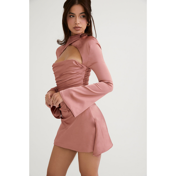Vrouw in roze satijnen jurk met lange mouwen en open schouder, modieuze kleding, elegante avondjurk, trendy damesmode, stijlvolle outfit.