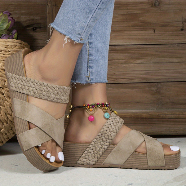 Beige sandalen met gevlochten bandjes en sleehak, gedragen met enkelbandje en spijkerbroek. Trendy zomerschoenen voor dames.