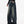 Vrouw in zwarte top en wijde, vintage jeans met sneakers. Modetrend, casual streetwear, comfortabele denimstijl, urban outfit.