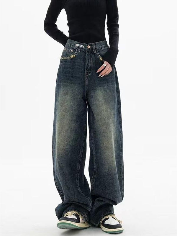 Vrouw in zwarte trui draagt wijde, vintage jeans met sneakers. Modieuze streetwear, casual stijl, oversized denim look.