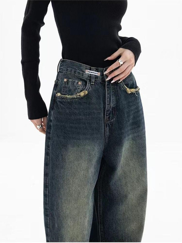 Vrouw in zwarte trui draagt wijde, vintage jeans met rafelige zakken. Modieuze casual outfit, trendy denim stijl.