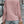 Vrouw in roze geribbelde trui en blauwe jeans, rugaanzicht, met beige clutch. Modieuze dameskleding, casual herfstoutfit, stedelijke achtergrond.