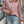 Vrouw in roze geribbelde trui met rits, draagt blauwe jeans en witte tas, houdt koffiebeker vast. Stijlvolle herfstmode, casual outfit.