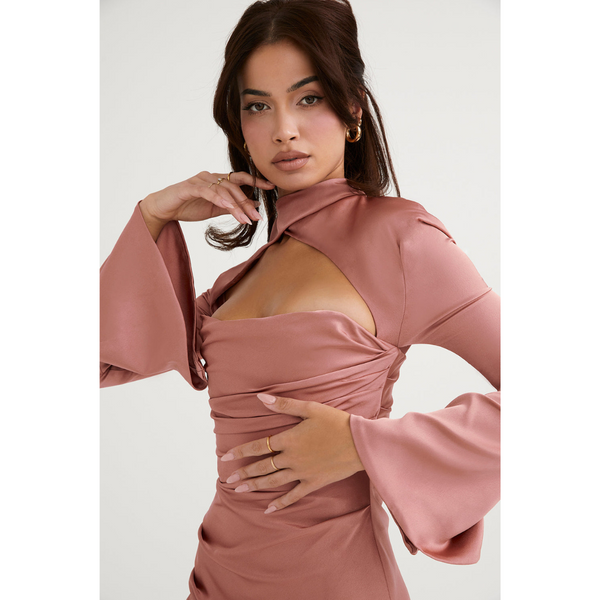 Vrouw in elegante roze satijnen jurk met lange mouwen en open schouderontwerp, modieuze avondkleding, stijlvolle damesmode.