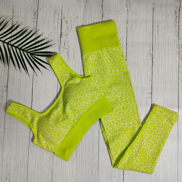 Neongele sportbeha en legging set met luipaardprint op witte houten achtergrond, perfect voor fitness en yoga. Trendy sportkleding voor dames.