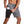 Man in grijze sportshorts met zijvak, toont smartphone-opslag. Ideaal voor hardlopen, fitness. Comfortabele, ademende stof.