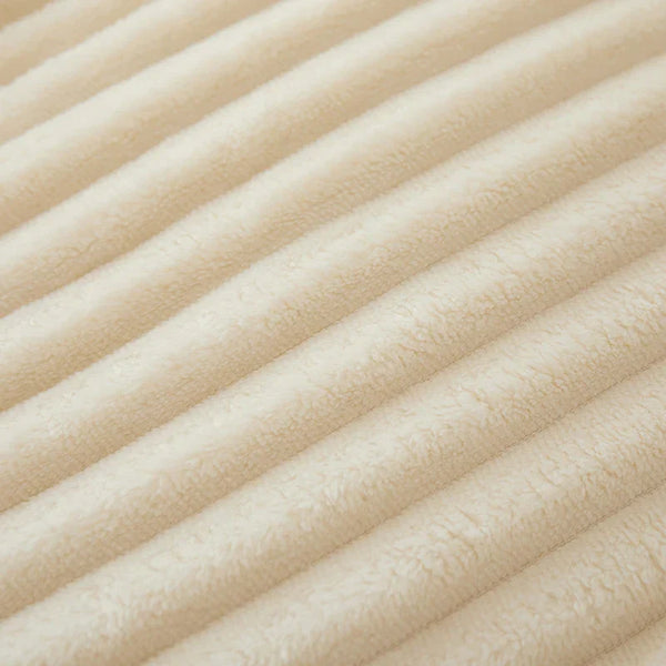 Geribbelde beige fleece stof close-up, zachte textuur, ideaal voor warme dekens en kleding. Perfect voor wintermode en interieurdecoratie.