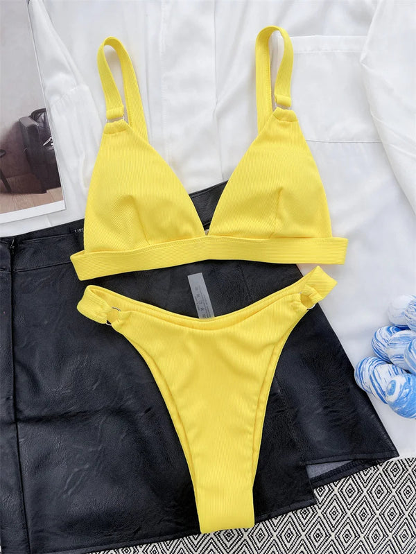 Gele bikini set met triangel top en hoge taille slip, liggend op zwart-witte achtergrond. Perfect voor zomerse stranddagen en zwembadfeesten.