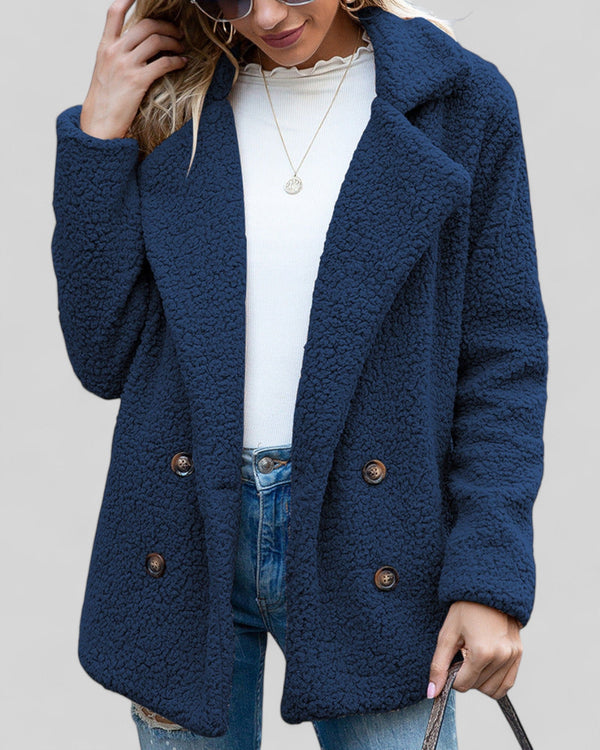 Vrouw in blauwe teddyjas, witte trui en spijkerbroek. Stijlvolle wintermode, trendy dameskleding, casual outfit.