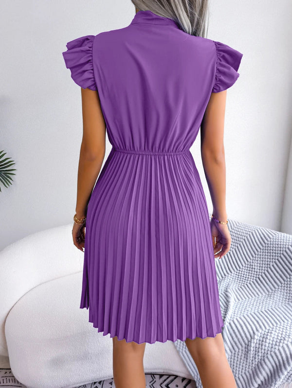 Paarse geplooide jurk met korte mouwen, gedragen door vrouw, rugaanzicht. Elegante damesmode, trendy zomerjurk, stijlvolle kleding.