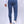 Man in blauwe slim-fit broek en witte sneakers, gezien van achteren. Stijlvolle herenmode, casual outfit, moderne kledingstijl.