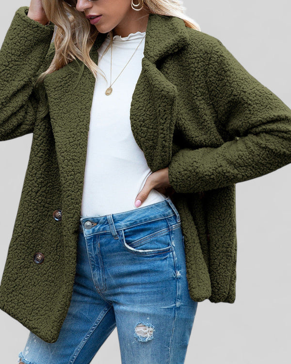 Vrouw in groene teddyjas, witte top en gescheurde jeans. Modieuze herfstkleding, casual stijl, comfortabele damesoutfit.
