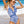 Vrouw in blauw-witte bloemenbadpak op strand, zonnebril, golven op achtergrond. Zomermode, strandkleding, stijlvolle badmode.