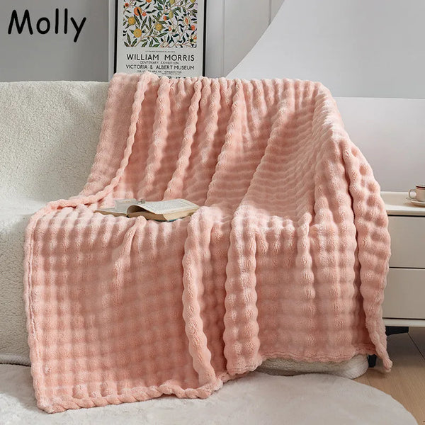 Zachte roze fleece deken op een witte bank met open boek, perfect voor woonkamer decor en comfort. Ideaal voor gezellige avonden thuis.